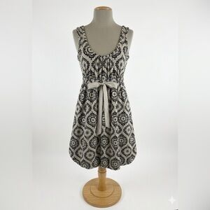 sleeveless sundress featuring a bubble hem and a velvet bow accent at the waist.